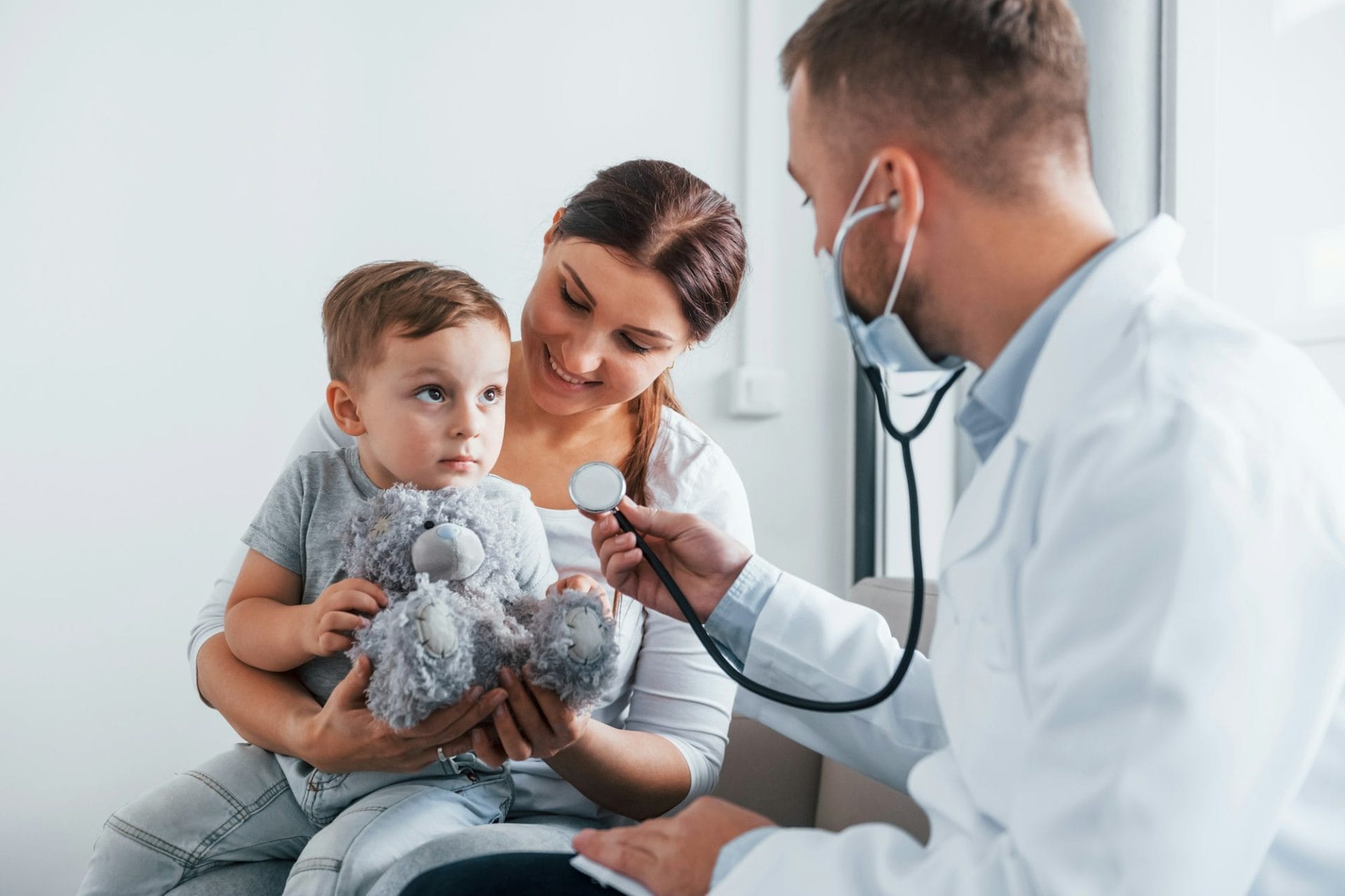 Helping the child. Two doctors in white coats is in the clinic working together