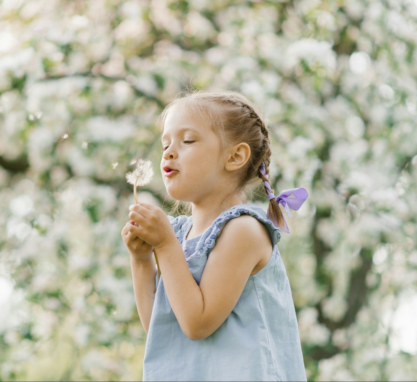 Beautiful child with dandelion flower. Happy kid having fun outdoors in spring park