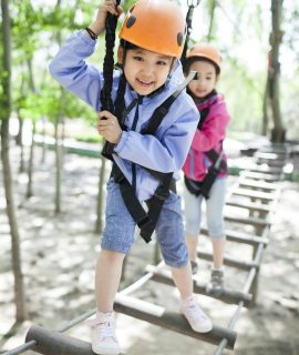 Happy children playing in tree top adventure park